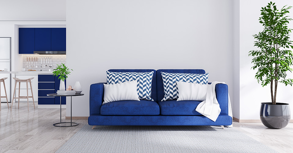 canapé convertible bleu dans salon lumineux avec cuisine ouverte pour location airbnb