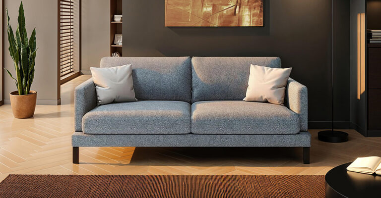 canapé convertible gris transformé en lit dans un studio avec coin nuit aménagé