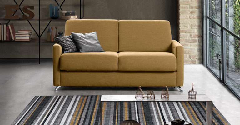 canapé convertible gris dans petite chambre d’hôtel avec décoration moderne et espace optimisé