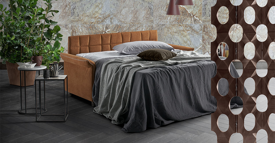 canapé convertible beige avec coussins et plaid dans un coin lecture cosy avec lampe et bibliothèque