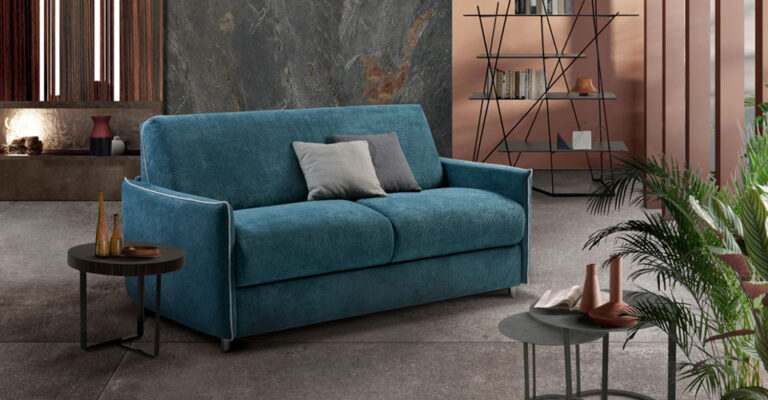 aspirateur nettoyant les recoins d’un canapé convertible avec embout fin entre les coussins