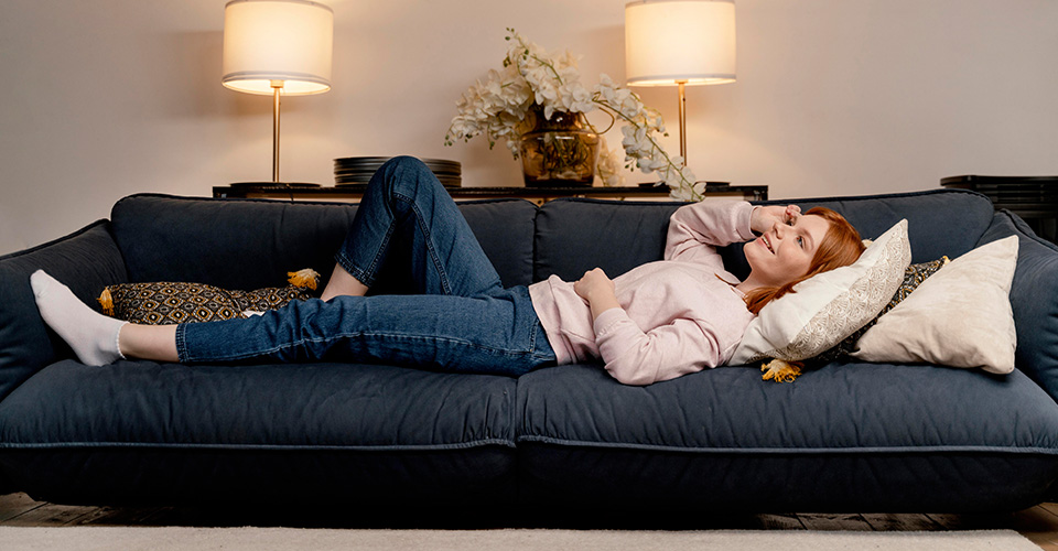Femme détendue dormant confortablement sur un canapé convertible